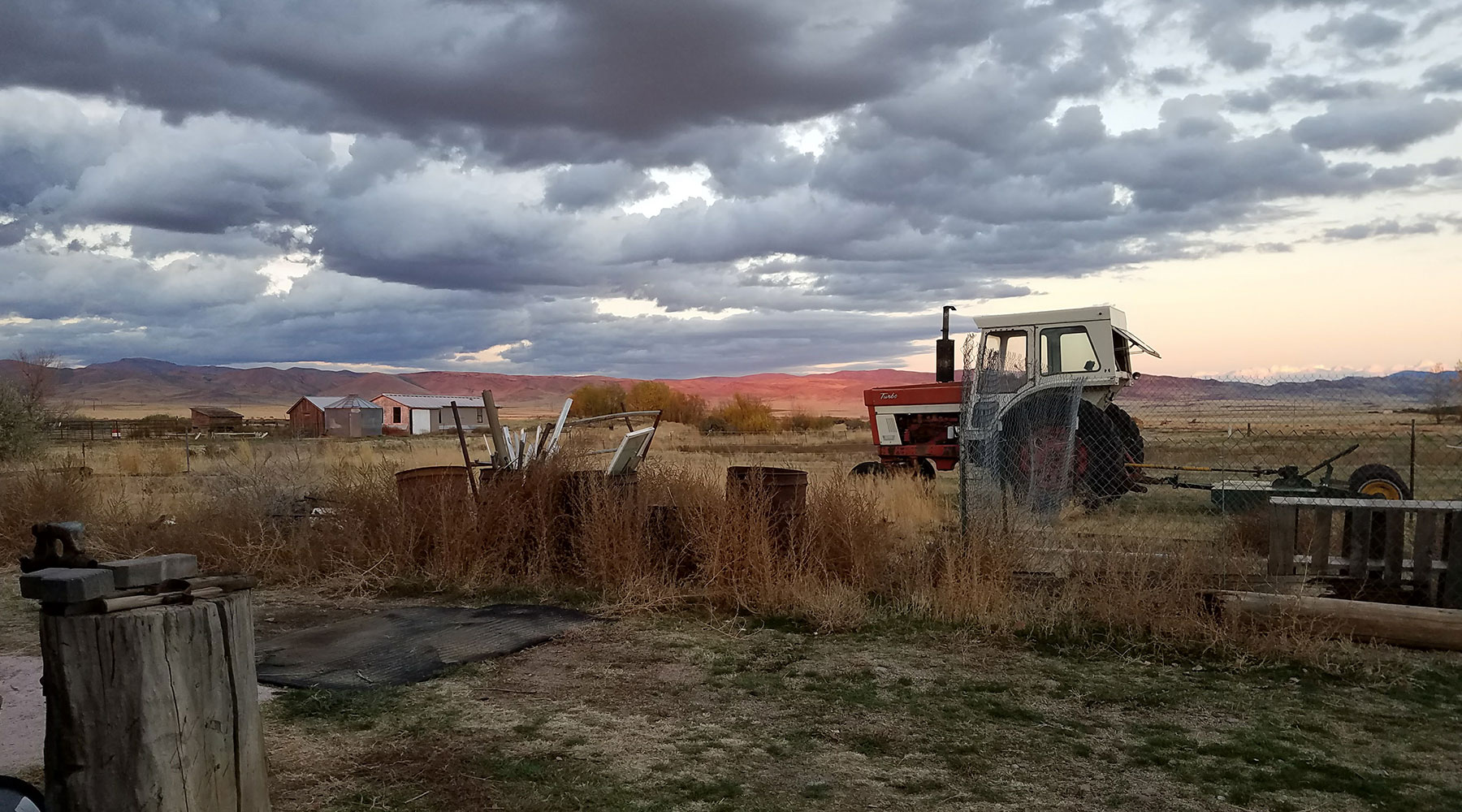 Idaho farm and antique tractor under cloudy sky