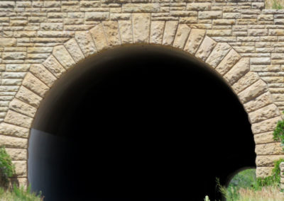 closeup of a road through a curved, brick tunnel